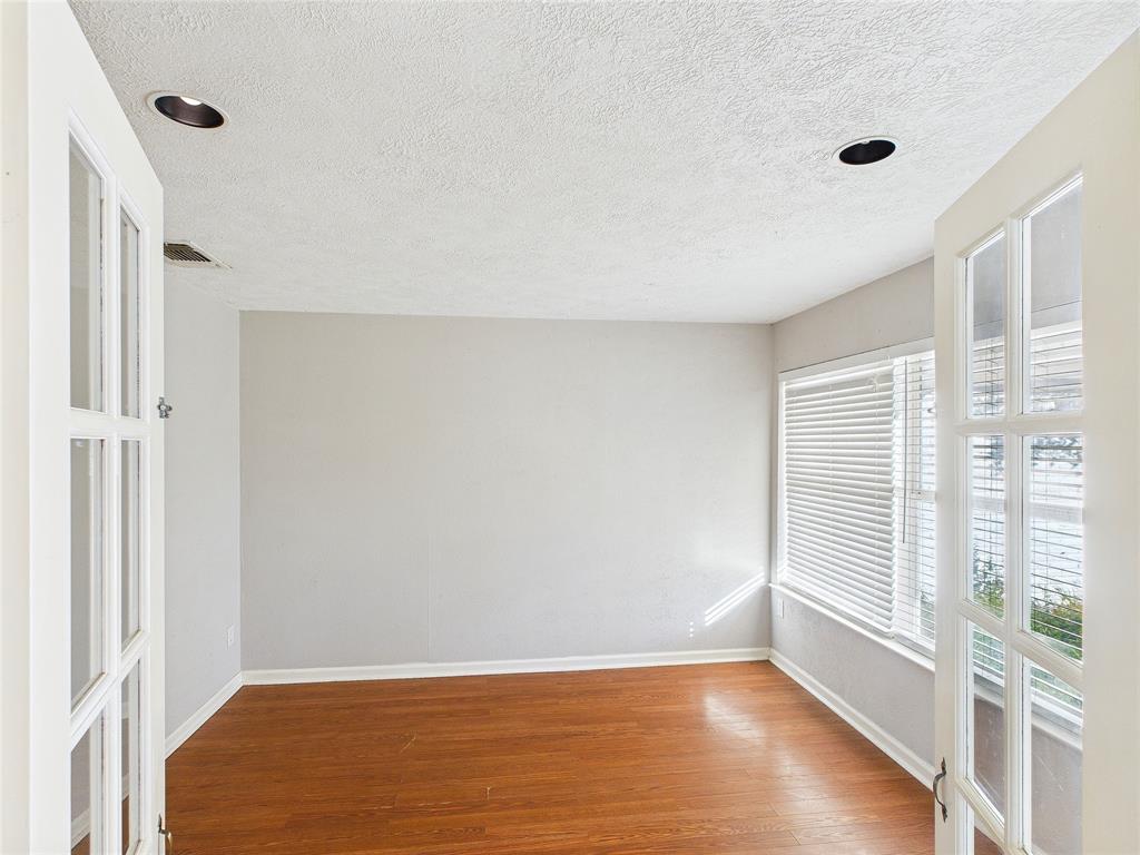 6909 Valhalla Road Fort Worth, TX 76116 - Photo 10 of 15 a view of an empty room with wooden floor and a window
