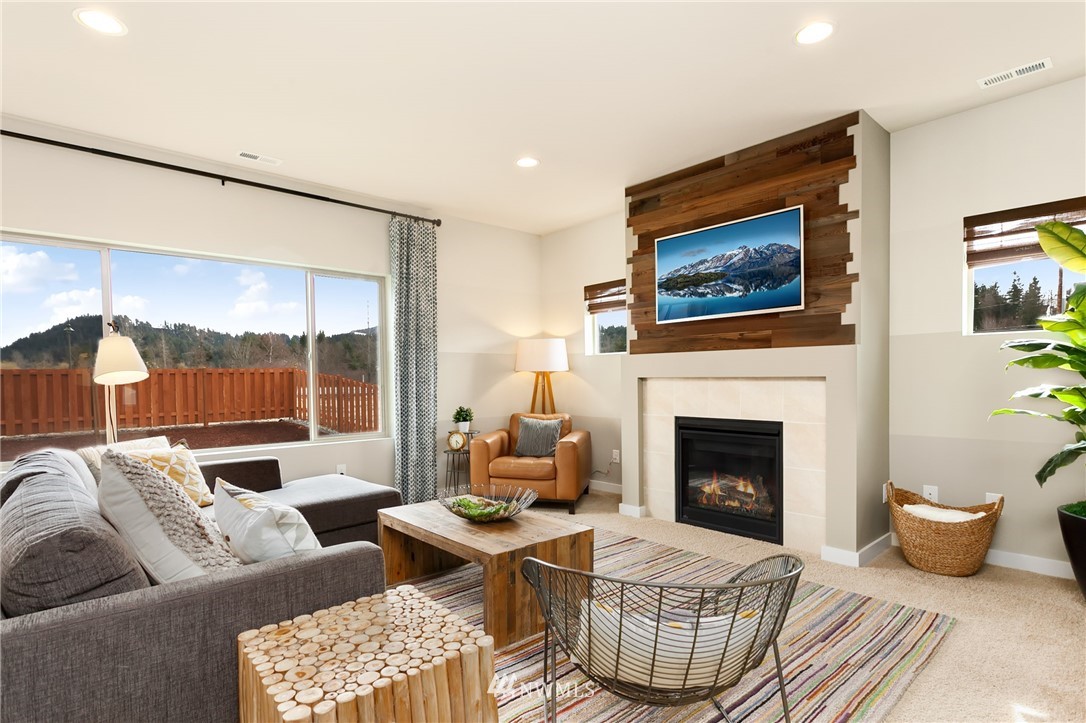 443 Partlon Street, Unit 75 Buckley, WA 98321 - Photo 8 of 25 a living room with furniture a rug and a fireplace