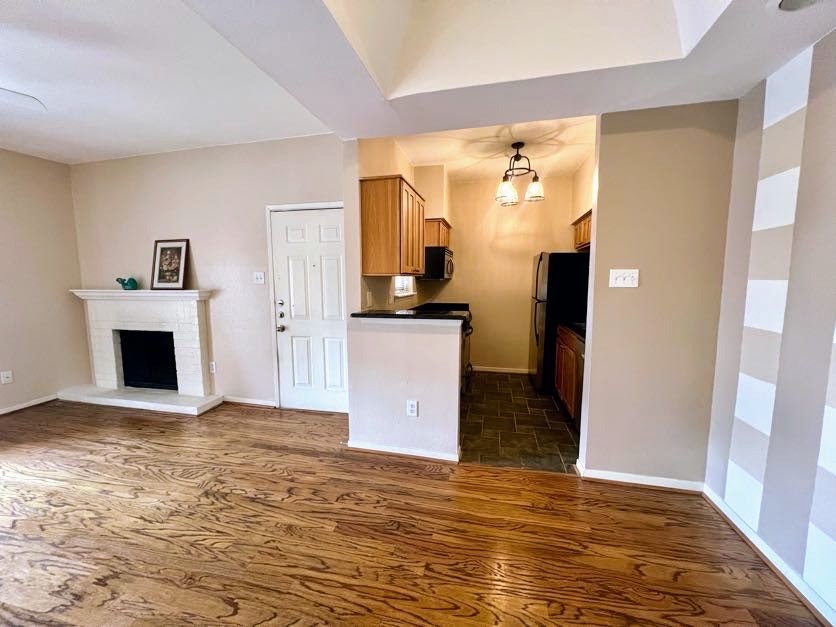 4041 Drake Street, Unit 118 Houston, TX 77005 - Photo 9 of 22 a view of empty room with wooden floor and fireplace