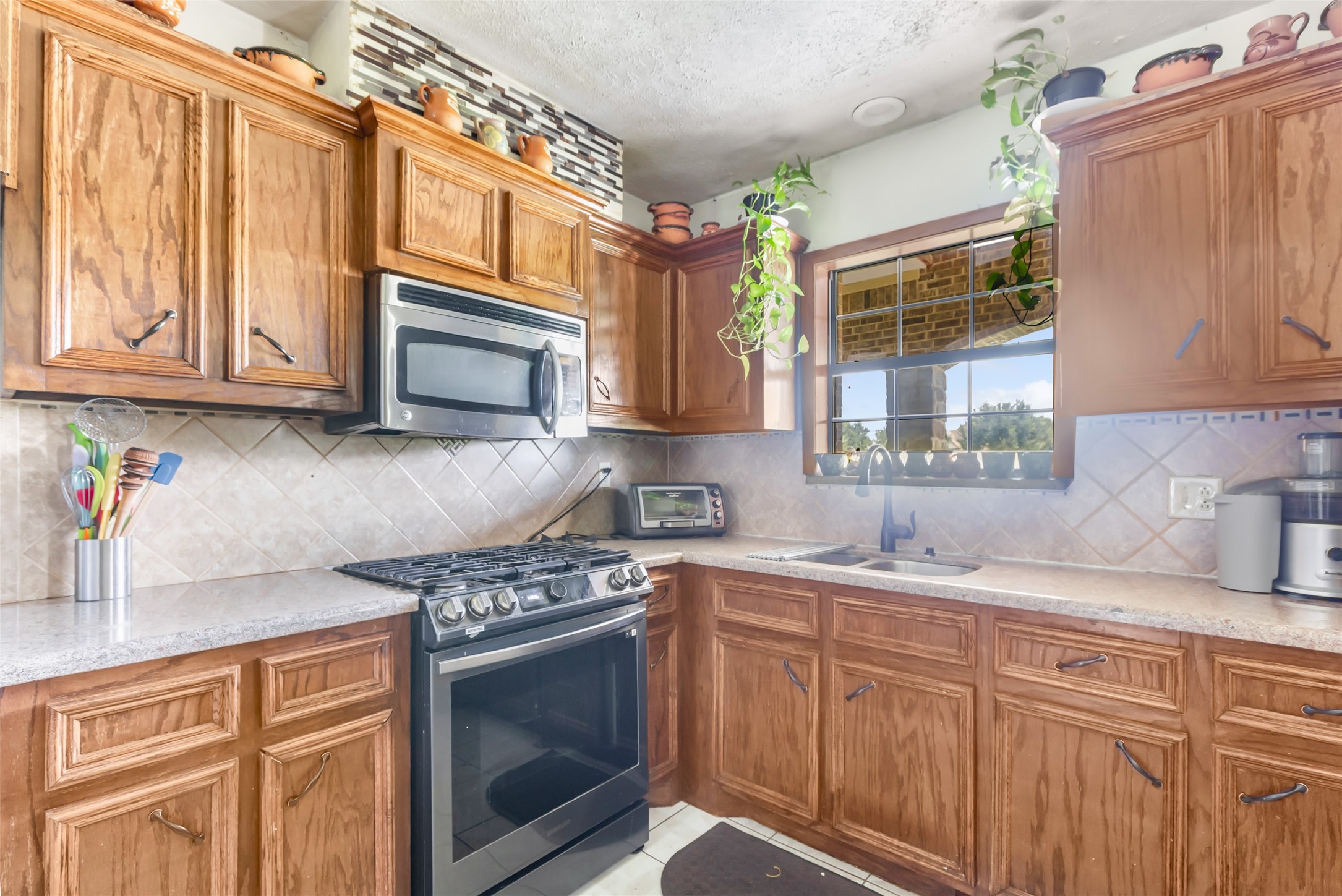 15123 Lindstrom Road Crosby, TX 77532 - Photo 3 of 39 a kitchen with stainless steel appliances granite countertop a sink stove and microwave