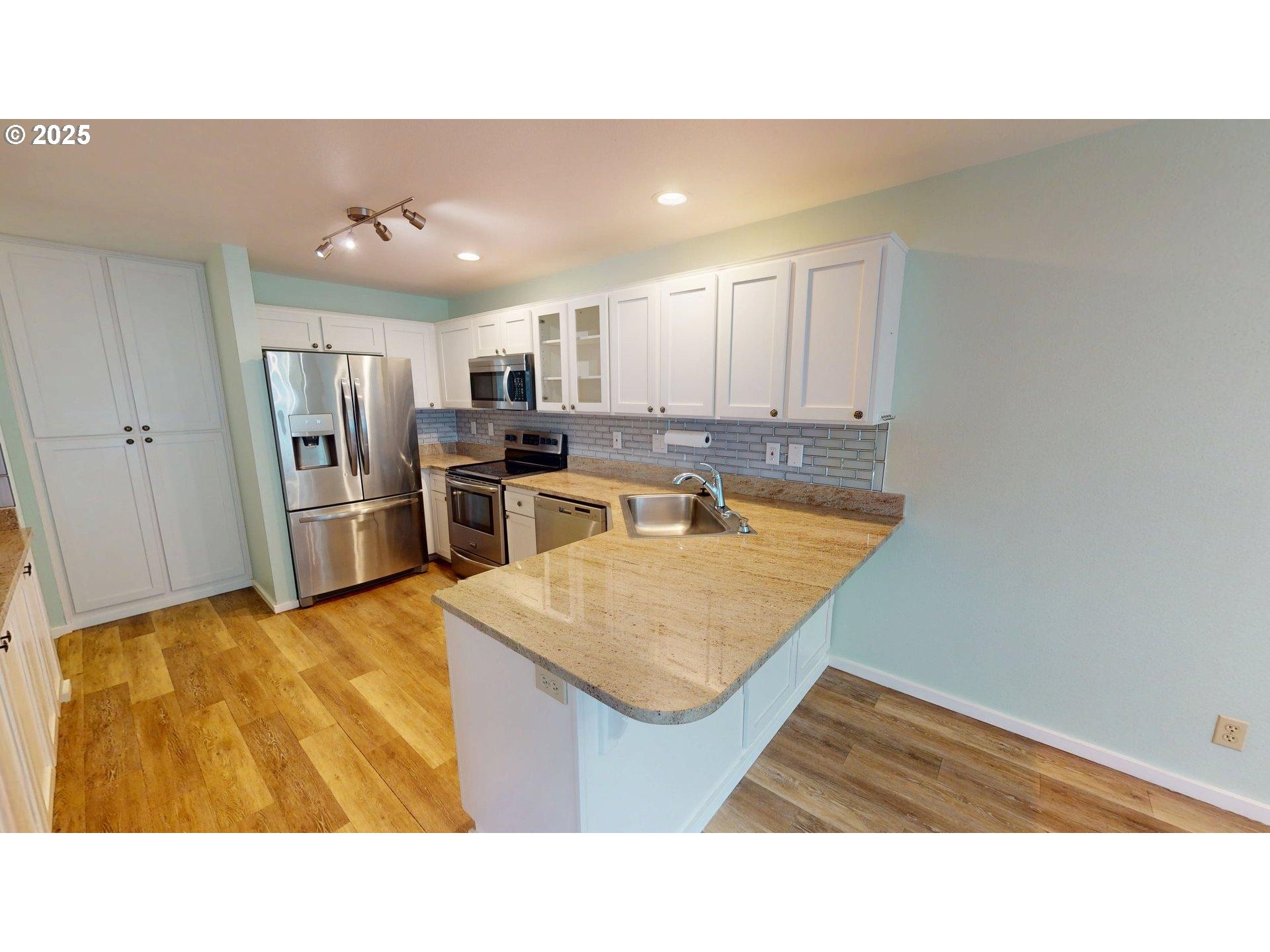 1455 Seacrest Lane, Unit 1A Brookings, OR 97415 - Photo 2 of 32 a kitchen with kitchen island granite countertop a sink refrigerator and microwave