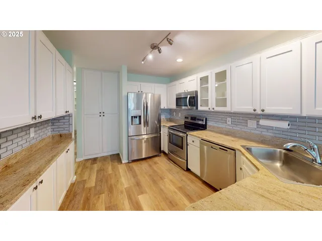 a kitchen with stainless steel appliances kitchen island granite countertop a sink refrigerator and microwave