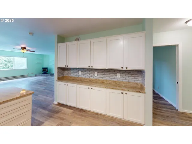 a kitchen with granite countertop white cabinets and a sink