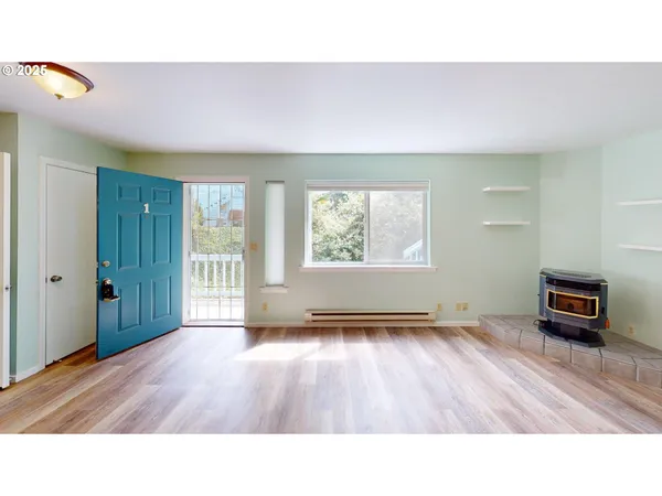a living room with a wooden floor and a large window