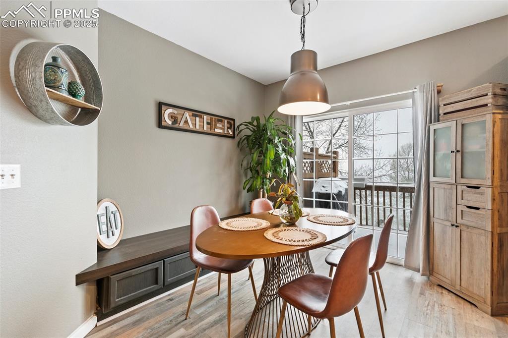 997 Burning Bush Point Monument, CO 80132 - Photo 10 of 34 a dining room with furniture a chandelier and wooden floor