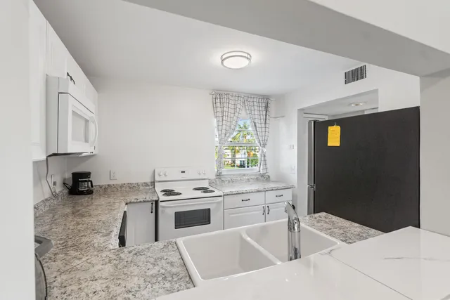 a kitchen with stainless steel appliances kitchen island granite countertop a sink stove and cabinets