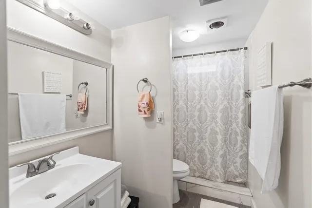 a bathroom with a sink vanity mirror and toilet