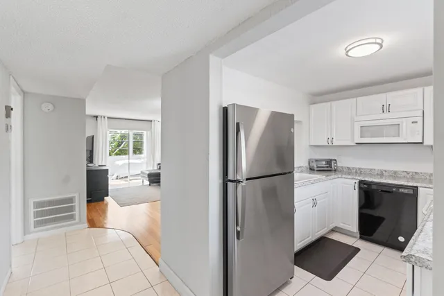 a kitchen with a refrigerator a stove top oven and cabinets
