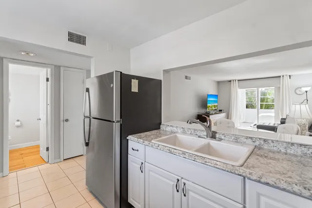 a kitchen with stainless steel appliances granite countertop a refrigerator and a sink