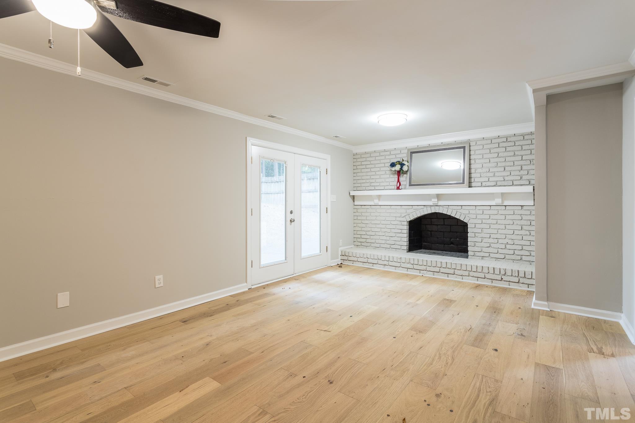 2013 Quail Ridge Road Raleigh, NC 27609 - Photo 3 of 28 an empty room with a fireplace and fan