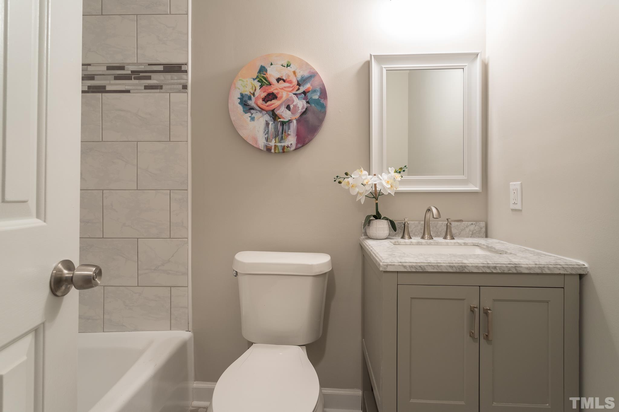 2013 Quail Ridge Road Raleigh, NC 27609 - Photo 22 of 28 a bathroom with a granite countertop toilet a sink and bathtub