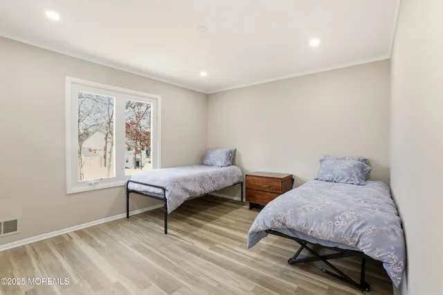 a bedroom with 2 bed and a window