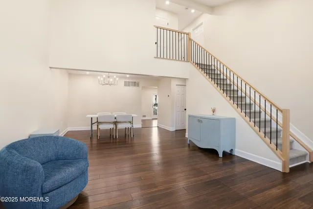 a living room with couches and pool view with wooden floor
