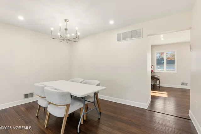 a view of a dining room with furniture wooden floor and chandelier