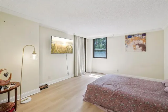 a bedroom with bed and paintings on the wall
