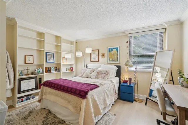 a bedroom with a bed wooden floor and window