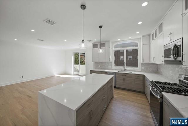 92 Franklin Street Tenafly, NJ 07670 - Photo 15 of 42 a large kitchen with kitchen island a large counter space a sink stainless steel appliances and cabinets