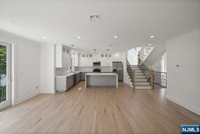 92 Franklin Street Tenafly, NJ 07670 - Photo 17 of 42 a large white kitchen with wooden floors and white stainless steel appliances