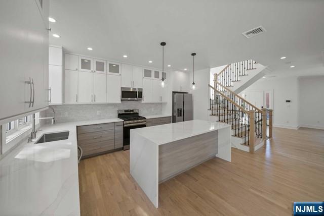 92 Franklin Street Tenafly, NJ 07670 - Photo 10 of 42 a large white kitchen with lots of counter space a sink and appliances