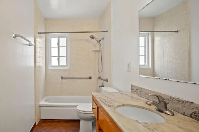a bathroom with a granite countertop sink toilet and shower