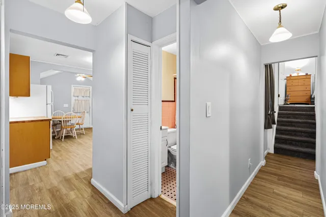 a view of a hallway with dining room and wooden floor