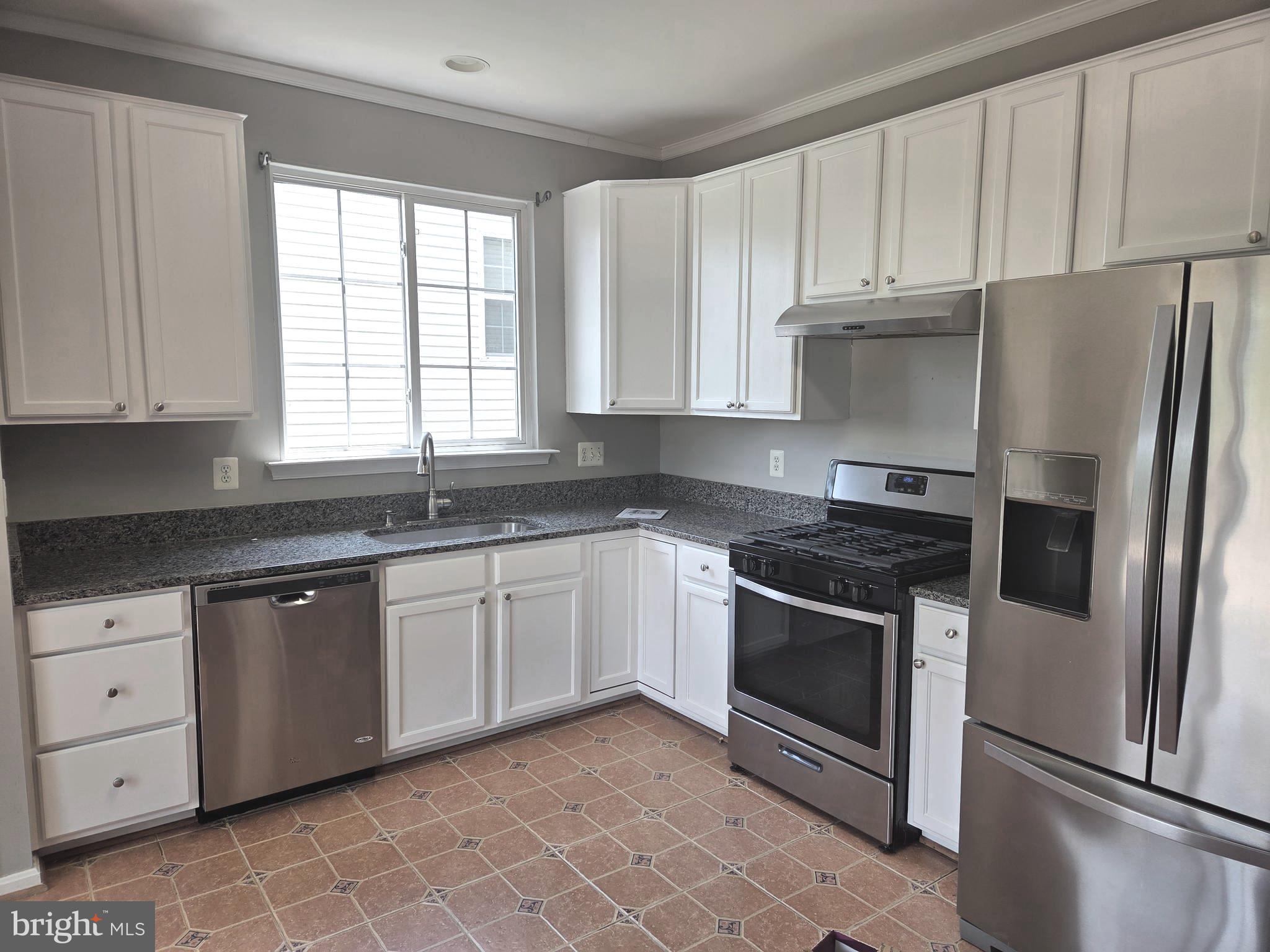 14387 Newbern Loop Gainesville, VA 20155 - Photo 2 of 38 a kitchen with granite countertop white cabinets white stainless steel appliances a sink and a window
