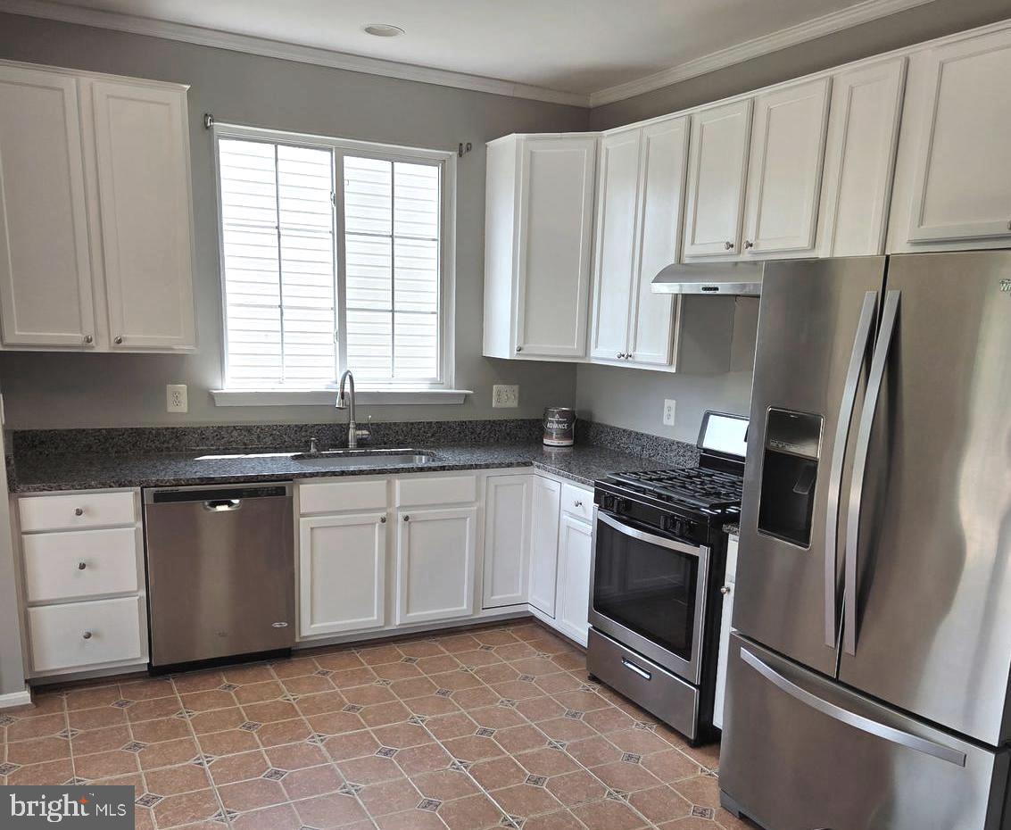 14387 Newbern Loop Gainesville, VA 20155 - Photo 8 of 38 a kitchen with stainless steel appliances granite countertop a stove a refrigerator and a sink