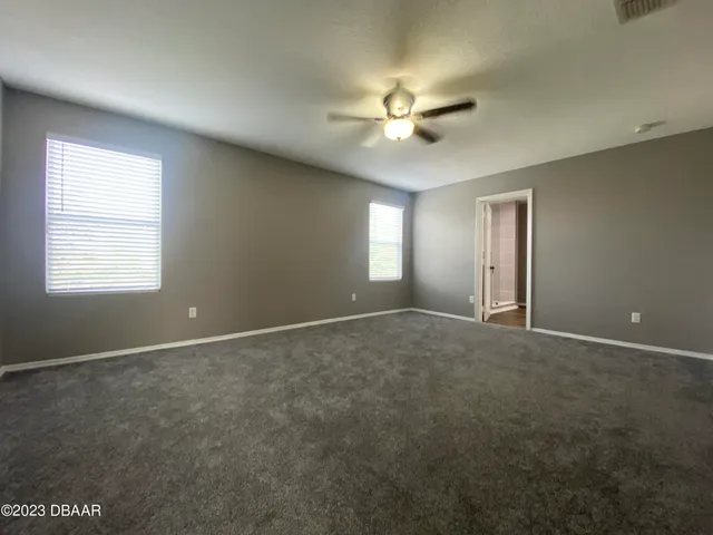 an empty room with a ceiling fan and a window