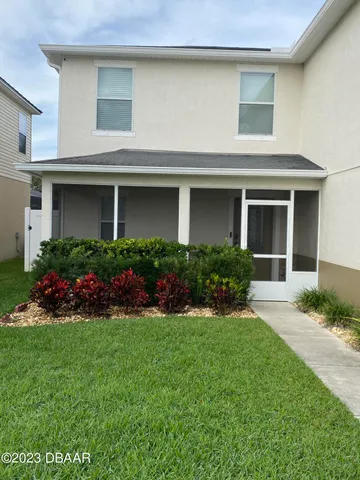 a front view of a house with a garden and yard