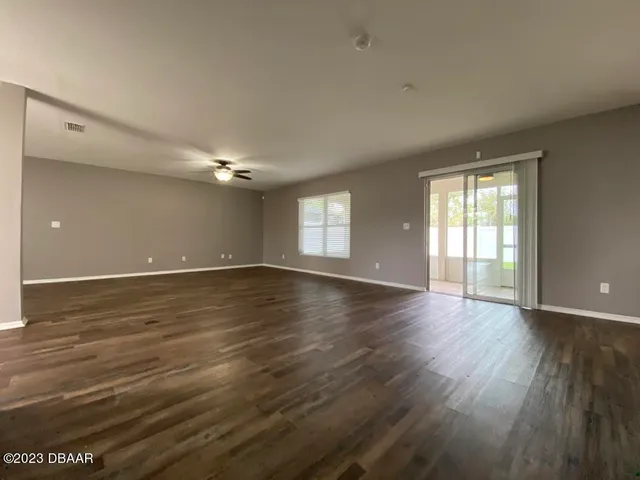 a large room with wooden floor and large windows