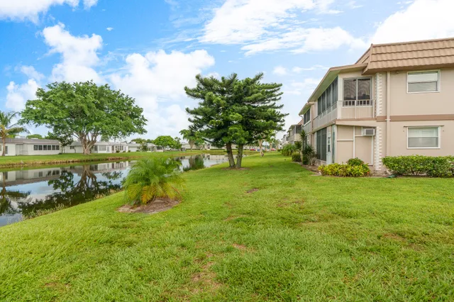 a view of a house with a yard and a fountain