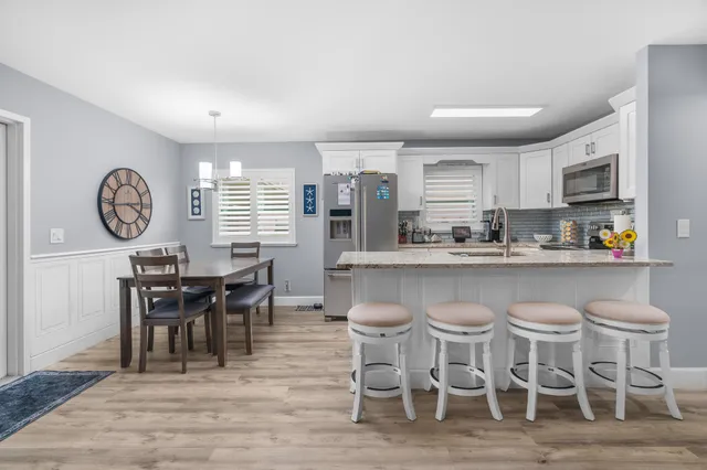 a dining room with stainless steel appliances a table and chairs