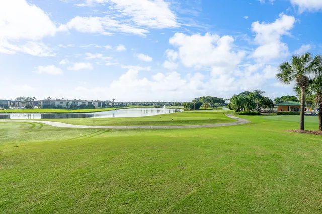 a view of a swimming pool with lawn chairs under an umbrella