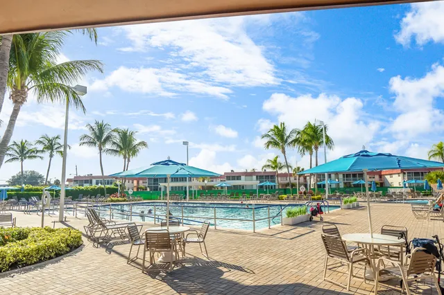 a room with lots of tables a large window and chairs