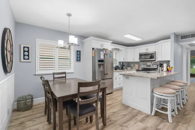 a kitchen with refrigerator a sink and chairs
