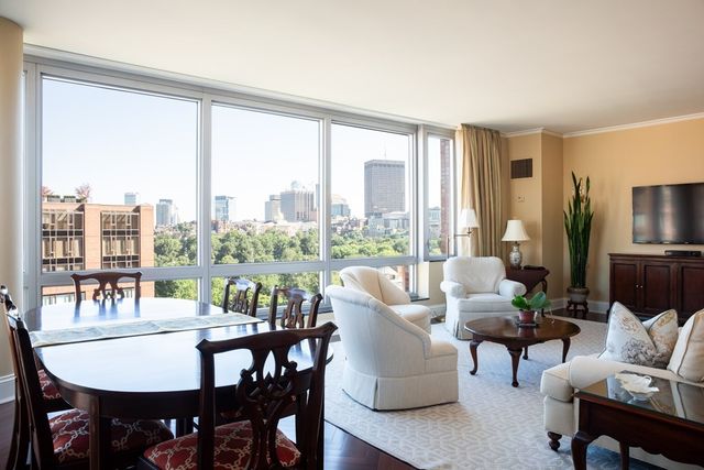 a dining room with furniture a rug and a floor to ceiling window