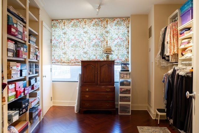 a view of walk in closet with clothes and shoes