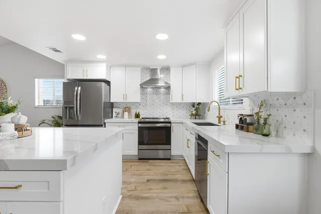a kitchen with stainless steel appliances granite countertop a stove a sink and a refrigerator