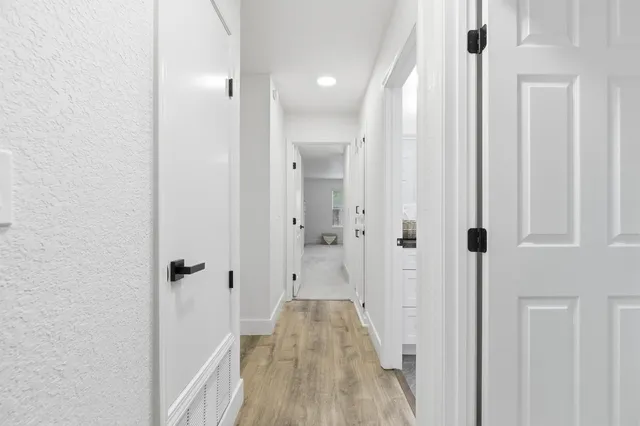 a view of a hallway with wooden floor and staircase