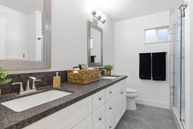 a bathroom with double sink and a mirror