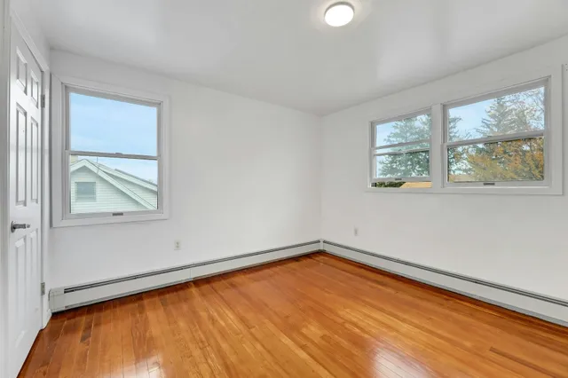 a view of a room with wooden floor and windows
