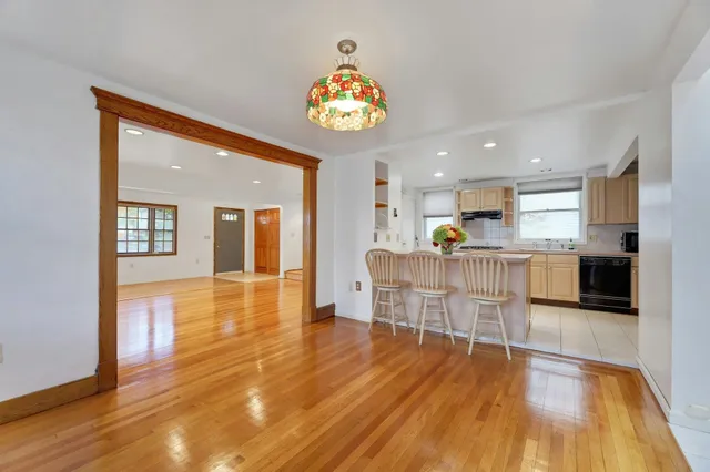 a view of a big room with wooden floor and a kitchen
