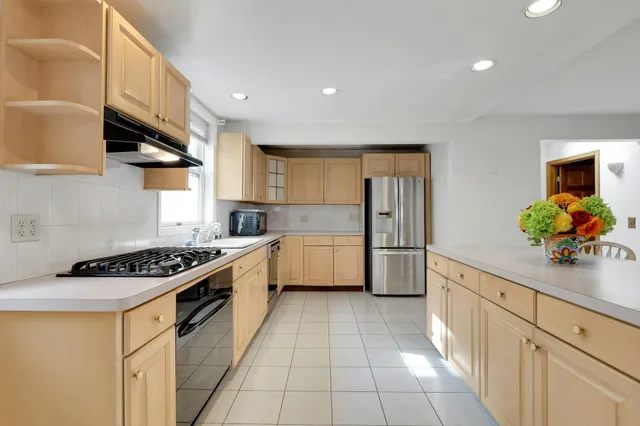 a kitchen with stainless steel appliances a stove a sink and a refrigerator