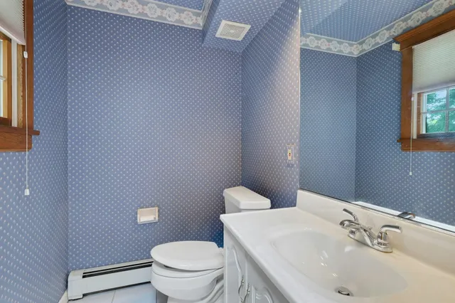 a bathroom with a sink a toilet and mirror