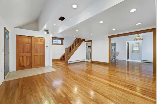 a view of a livingroom with wooden floor and staircase