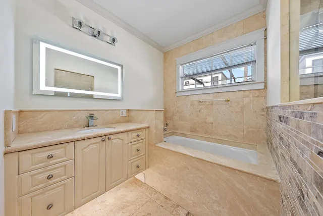a bathroom with a sink a large mirror and a bathtub