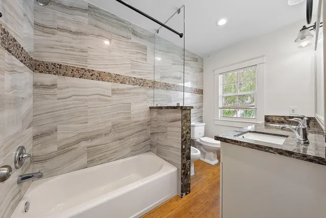 a bathroom with a tub sink and mirror