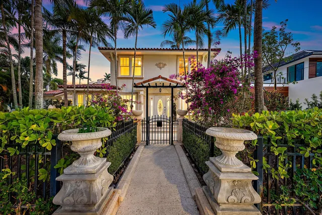 a view of a house with fountain and potted plants
