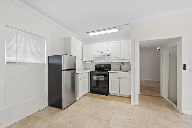 a kitchen with white cabinets and stainless steel appliances