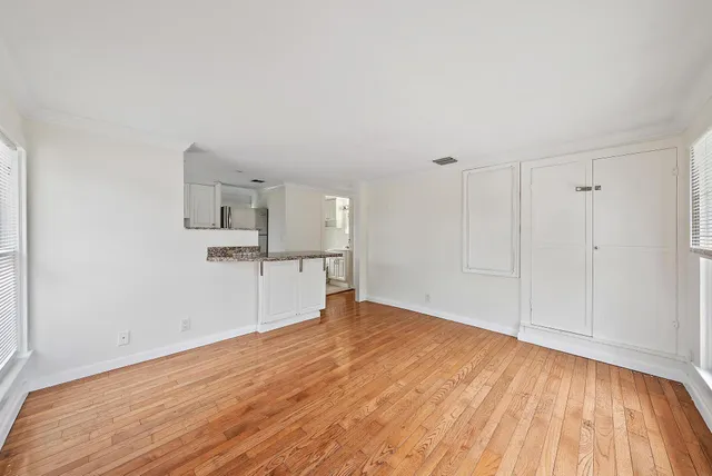 a view of empty room with wooden floor